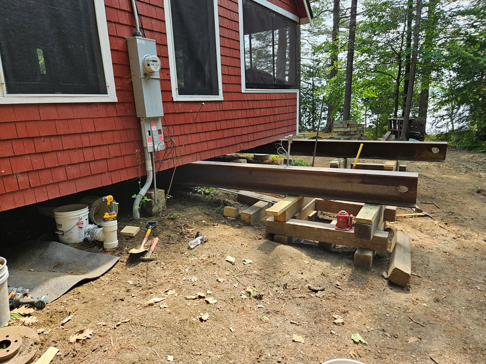 Camp in the process of being jacked, showing steel beams under the foundation.