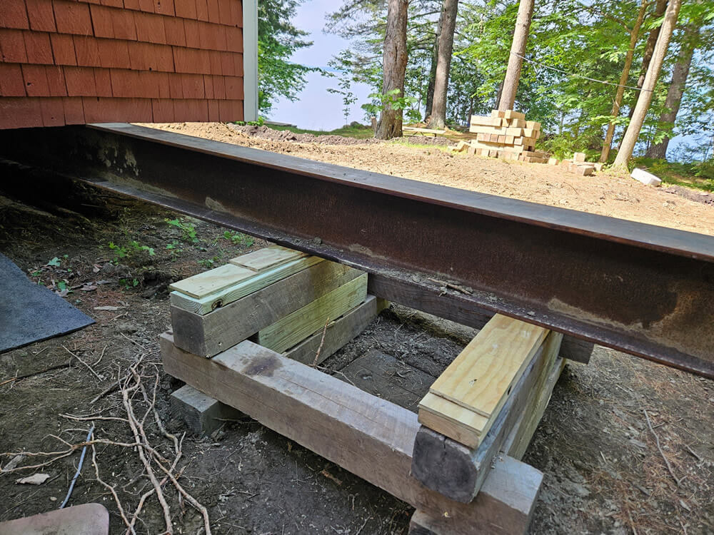 Close up photo of a supported steel beam under the foundation of a camp.