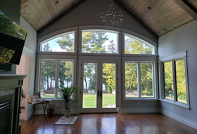 Great room with windows overlooking the lake and a fireplace.