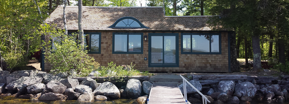 Waterfront home with rock retaining wall and dock.